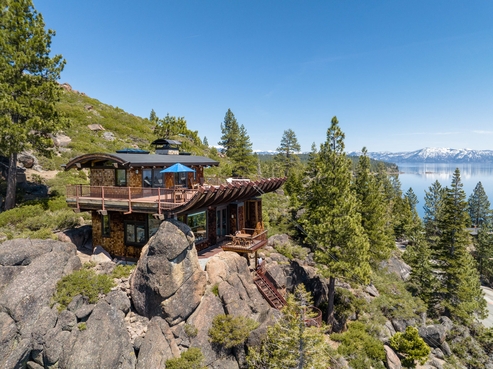 a house sitting on top of a mountain next to a lake