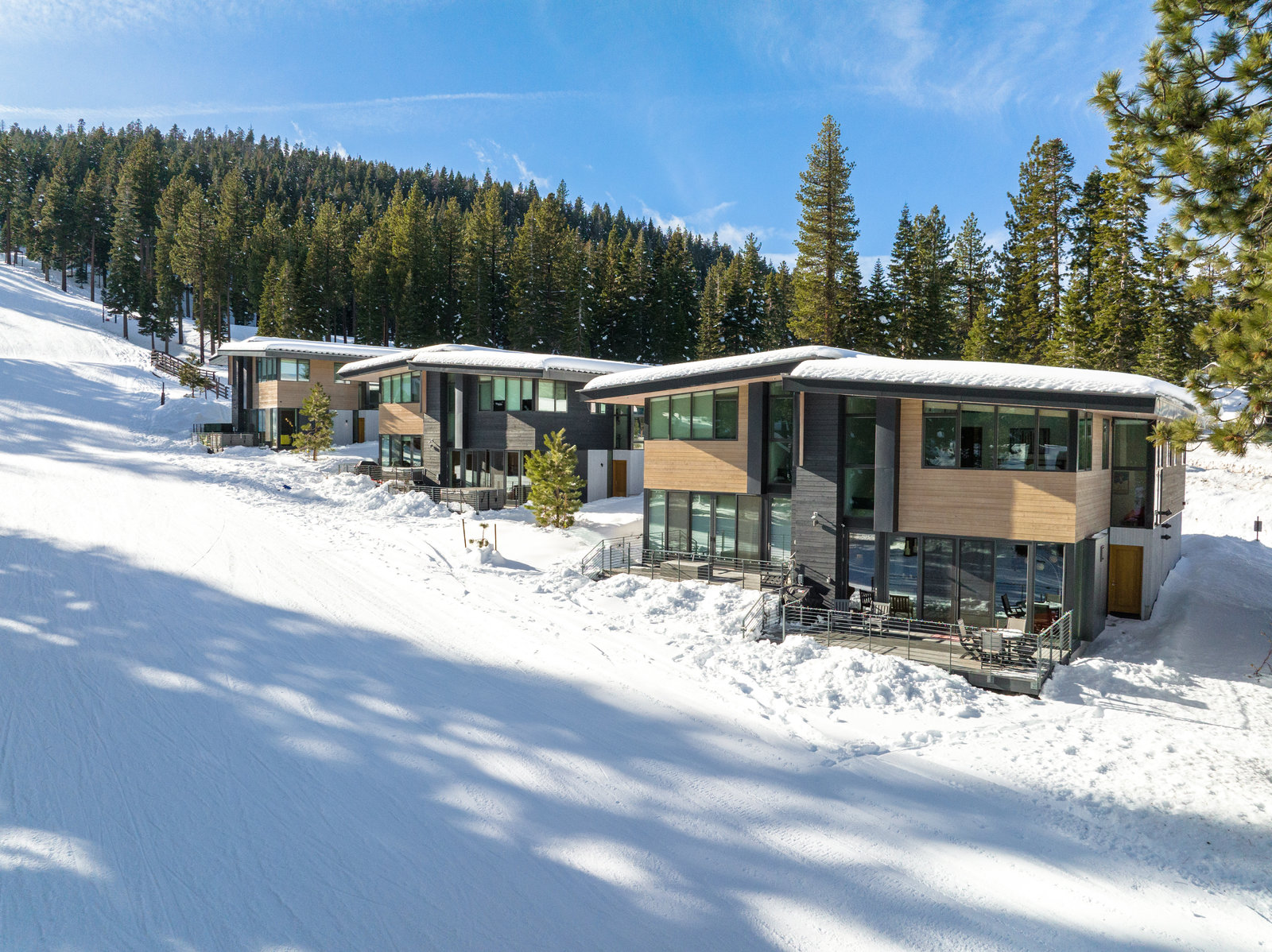 a group of houses sitting on top of a snow covered slope